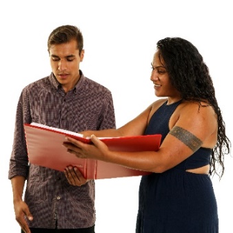 A woman showing something in a document to a man.